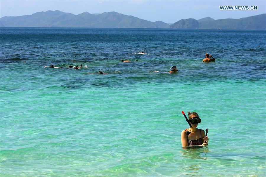 Vacationers swim in the sea in Palawan Province, the Philippines, Feb. 18, 2016.