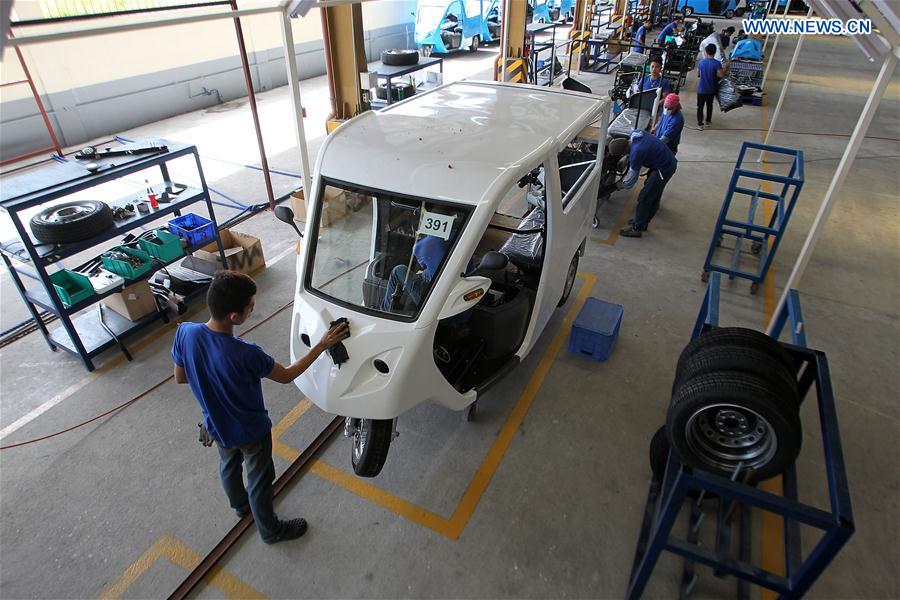 Workers assemble electric motor-powered tricycles or e-Trikes at a production line in Laguna Province, the Philippines, Feb. 24, 2016.